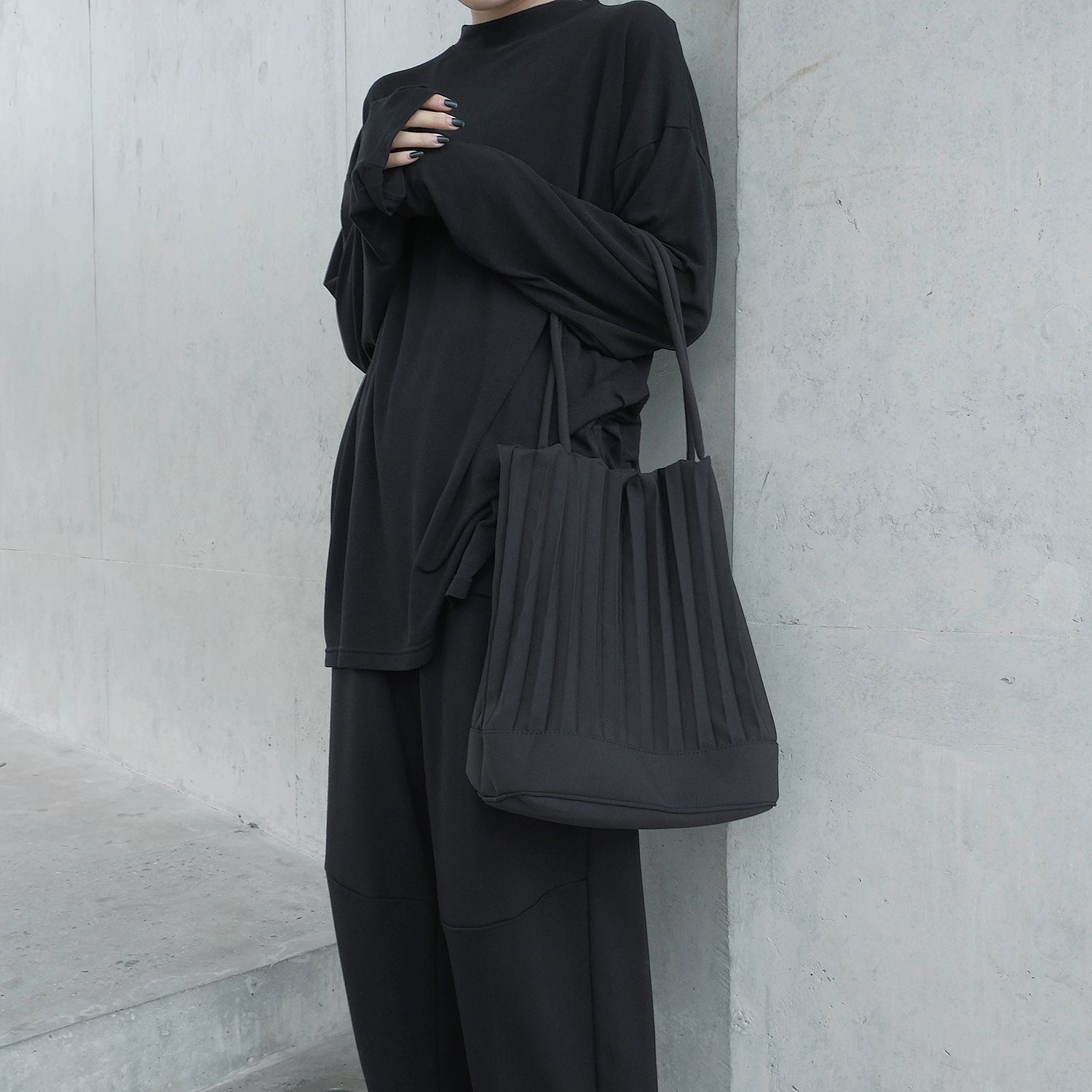 A stylish handmade ruched handbag in black, featuring a bucket shape and adjustable shoulder strap, perfect for various occasions.