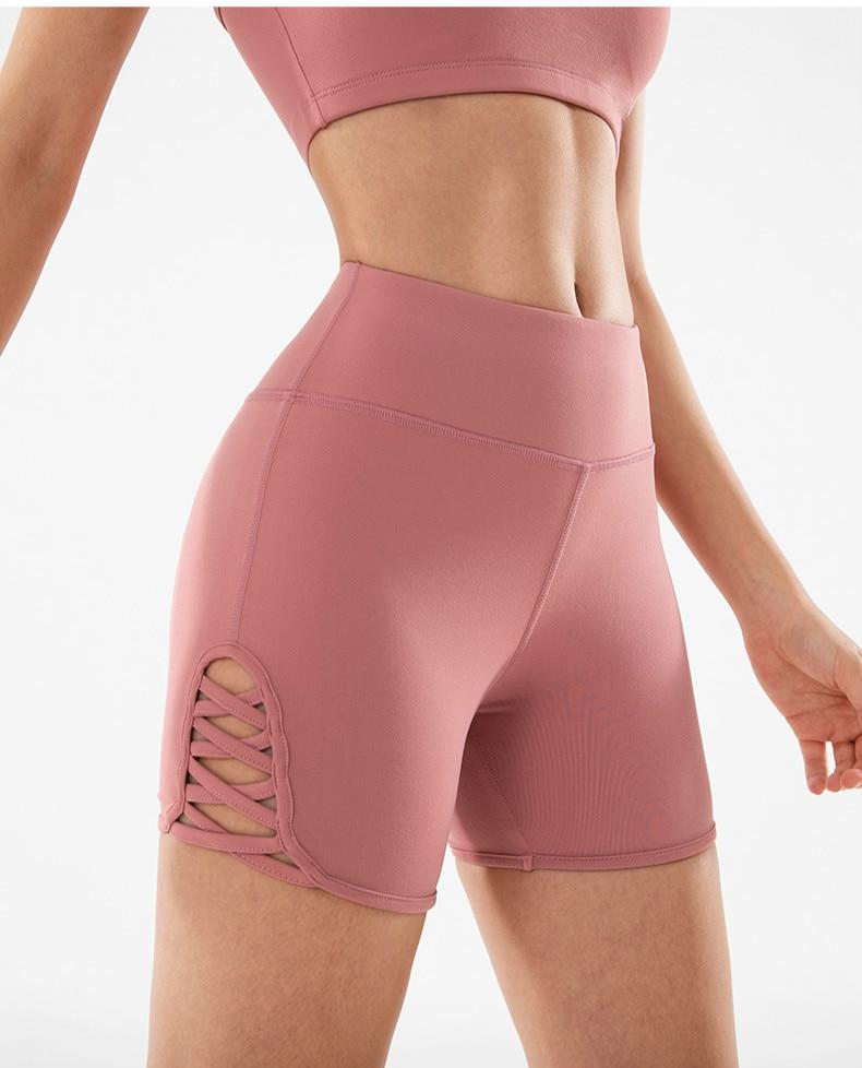 Women wearing high waist side cross strap fitness sport shorts in a gym setting, showcasing comfort and style during workout.