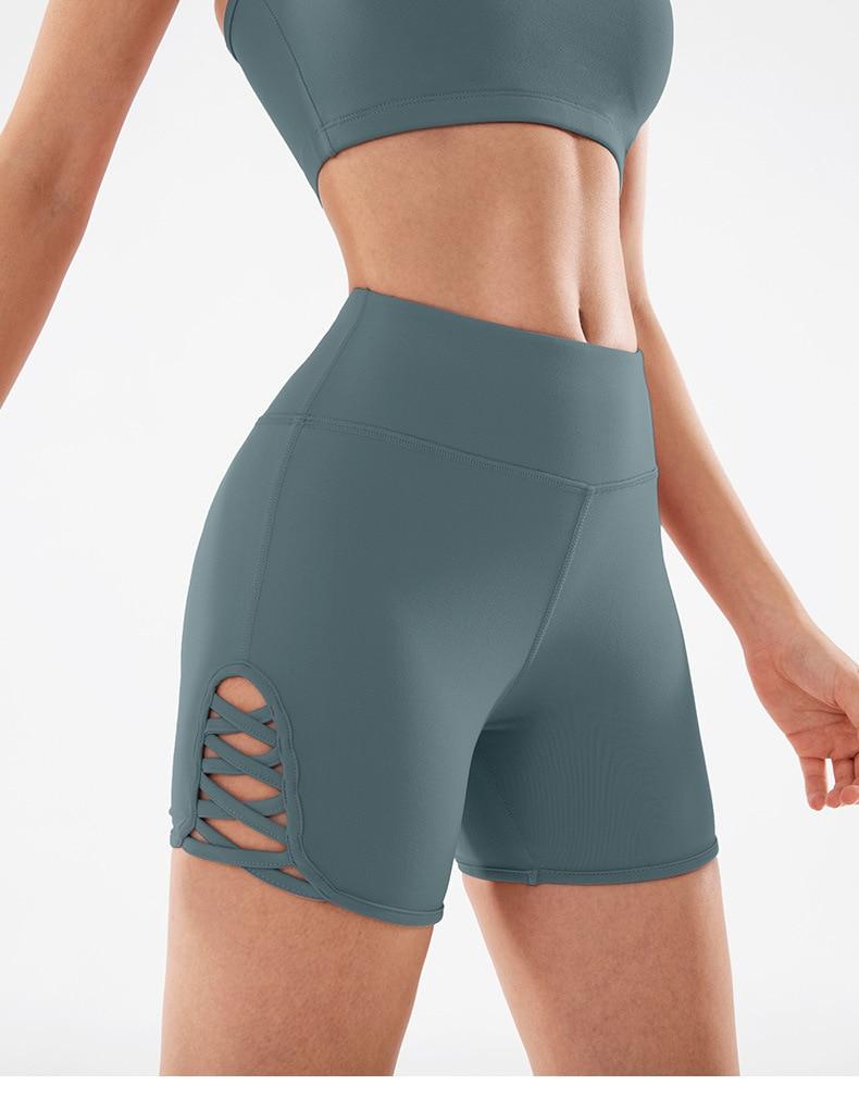 Women wearing high waist side cross strap fitness sport shorts in a gym setting, showcasing comfort and style during workout.