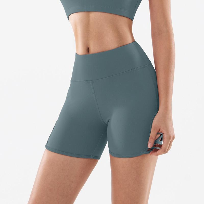 Women wearing high waist side cross strap fitness sport shorts in a gym setting, showcasing comfort and style during workout.