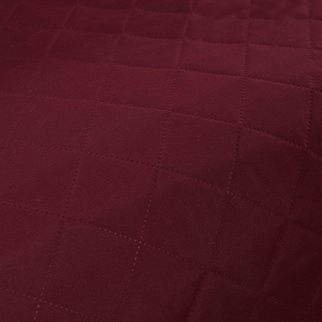 Waterproof quilted sofa cover in wine color, designed for protection and style, featuring delicate edges and anti-slip backing.