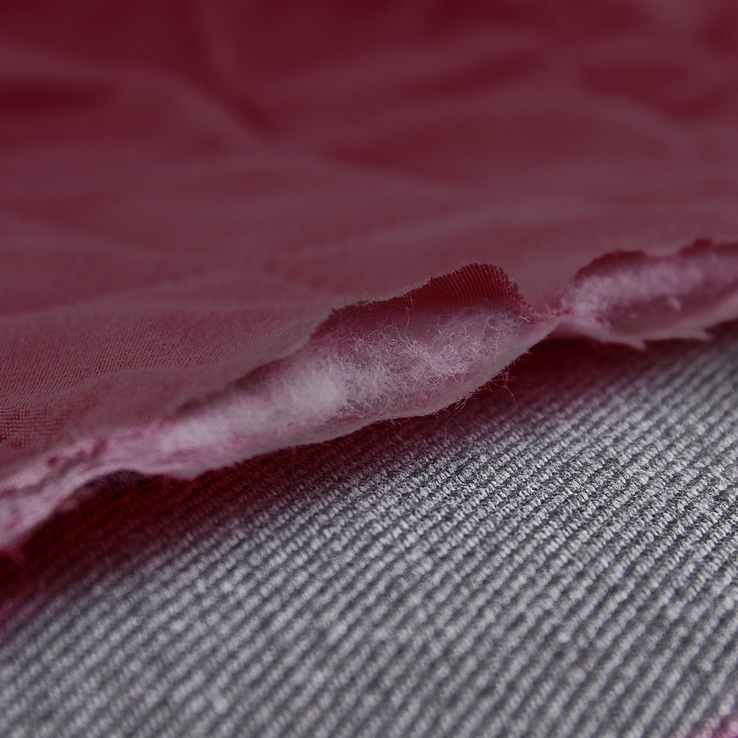 Waterproof quilted sofa cover in wine color, designed for protection and style, featuring delicate edges and anti-slip backing.