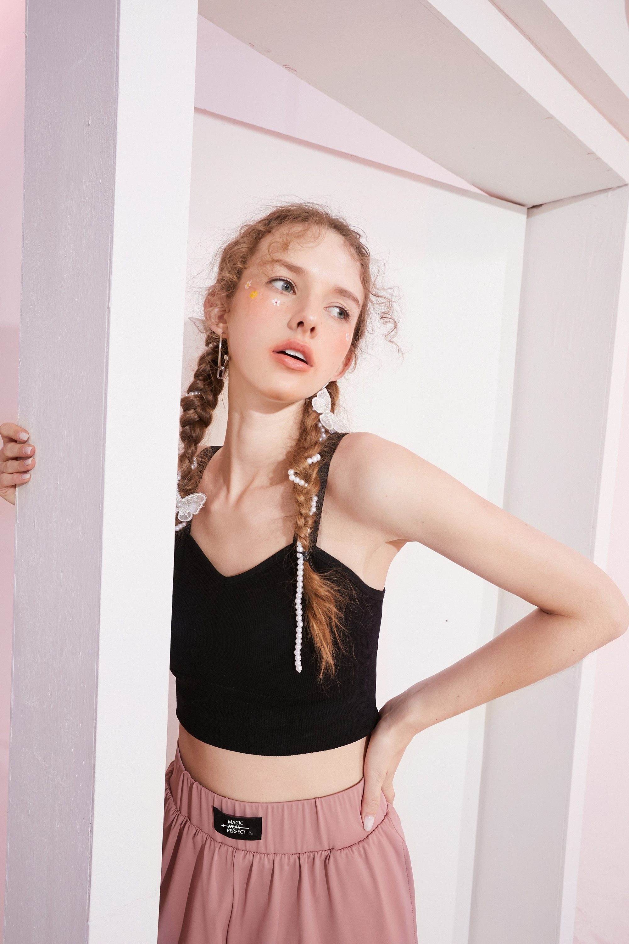 A stylish black and white crop top for women, featuring a minimalist design and sleeveless cut, perfect for casual spring outfits.