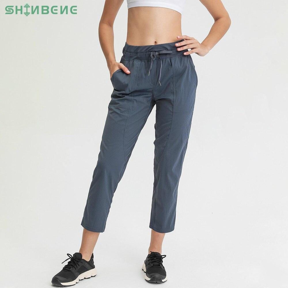 Women wearing STRIPE Mid Waist Drawstring Sport Gym Joggers, showcasing a stylish and comfortable fit for workouts.