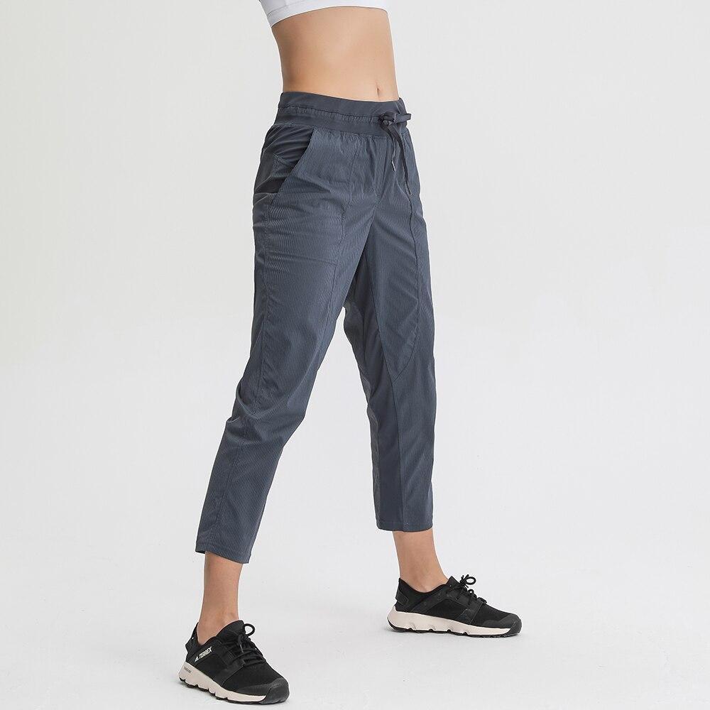 Women wearing STRIPE Mid Waist Drawstring Sport Gym Joggers, showcasing a stylish and comfortable fit for workouts.