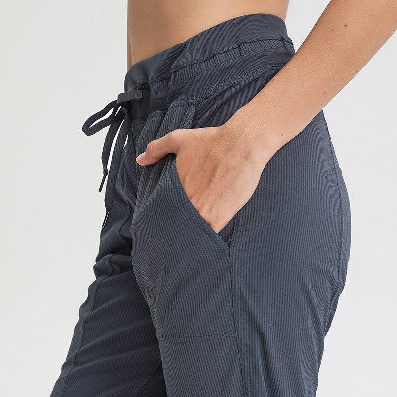 Women wearing STRIPE Mid Waist Drawstring Sport Gym Joggers, showcasing a stylish and comfortable fit for workouts.