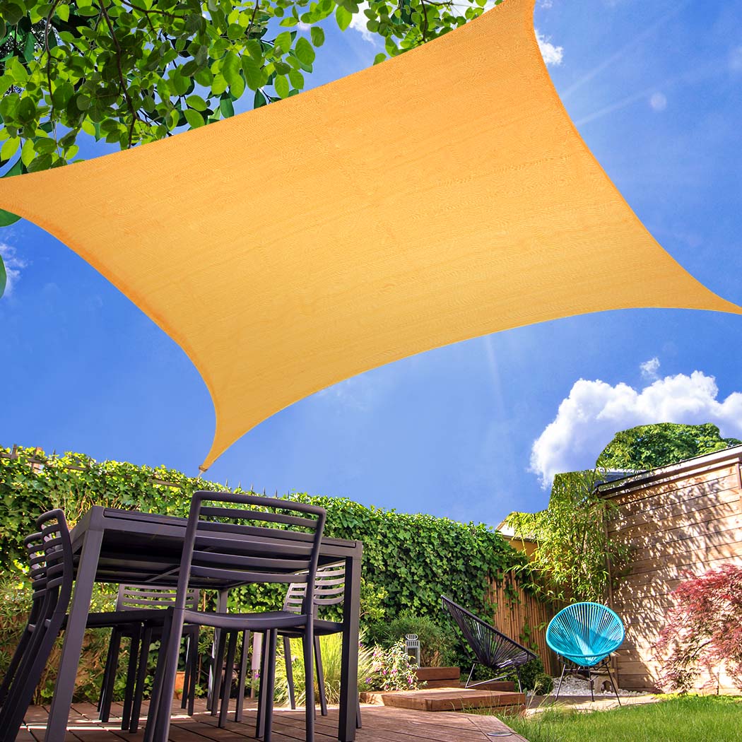 Beige rectangular sun shade sail cloth providing UV protection, installed outdoors for shade and comfort.