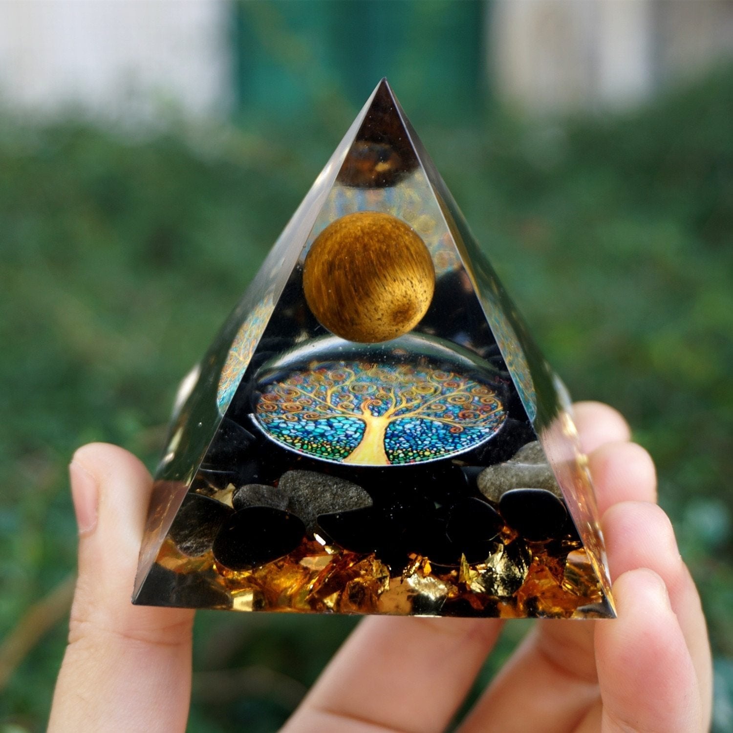 A beautifully crafted Tiger Eye Crystal Sphere & Obsidian Quartz Orgone Pyramid, showcasing its intricate design and natural stone texture.