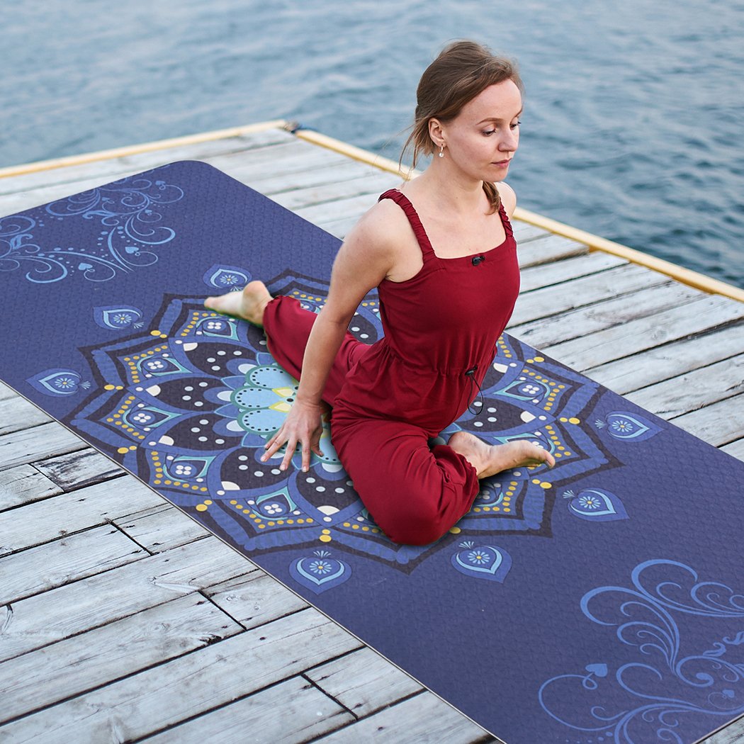 Eco-friendly TPE yoga mat with dual layer and non-slip surface, featuring traditional design and bonus carry bag for easy transport.