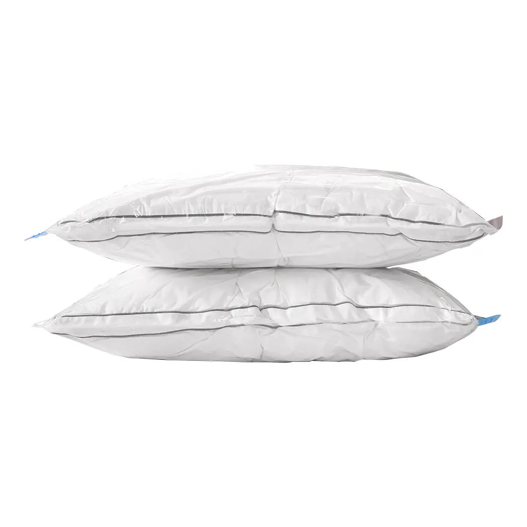 A set of transparent vacuum storage bags filled with clothes and quilts, showcasing their space-saving design and included air pump.