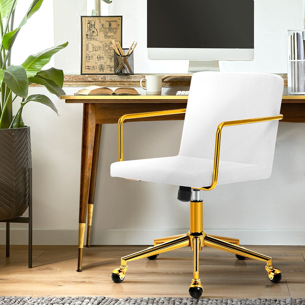 Caraway Velvet Office Chair with metallic brass base and armrests, featuring luxurious white upholstery and smooth ball-shaped castors.