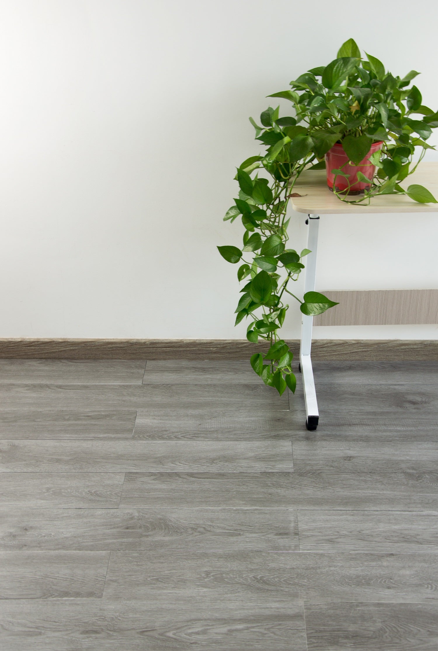 Self-adhesive vinyl floor tiles in ash wood grain, showcasing realistic wood texture and design.