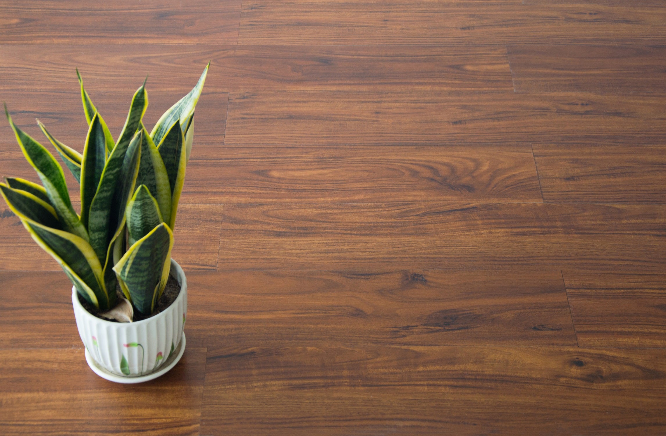 Self-adhesive vinyl floor tiles featuring a realistic walnut wood grain design, perfect for home renovation.