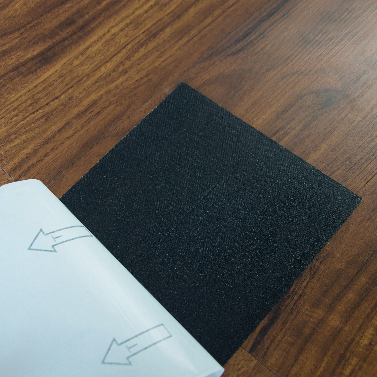 Self-adhesive vinyl floor tiles featuring a realistic walnut wood grain design, perfect for home renovation.