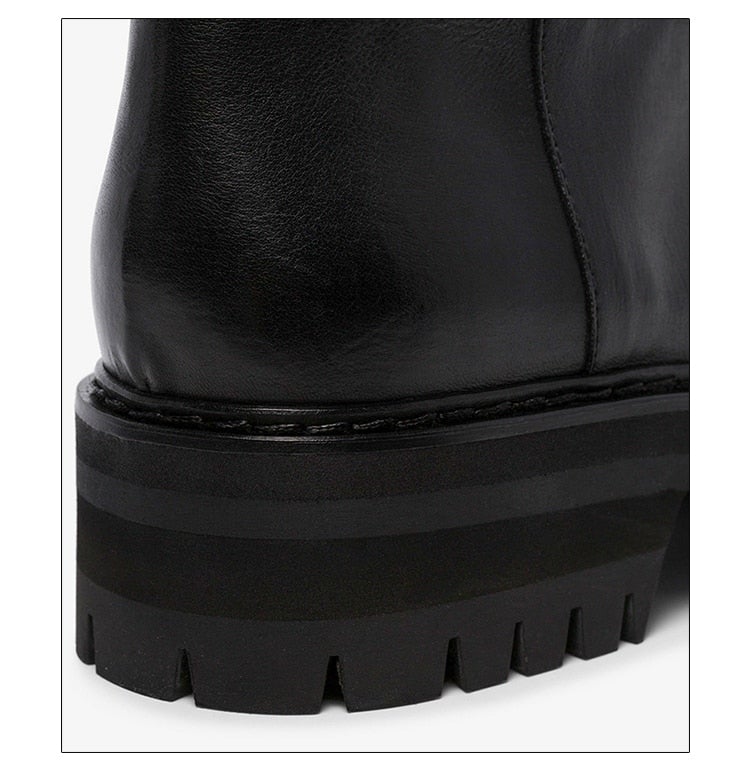 A pair of stylish black over-the-knee boots made from genuine leather, featuring a zipper closure and elastic design for a comfortable fit.