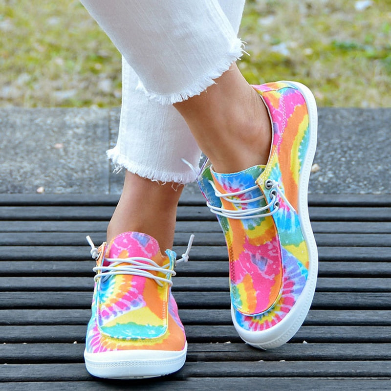 Stylish women's canvas shoes featuring a vibrant tie dye pattern and lace-up design, perfect for casual wear.
