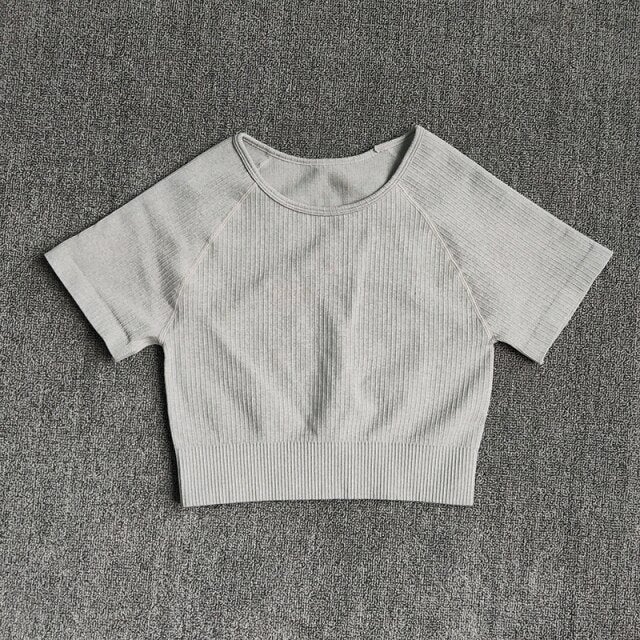 Women wearing a stylish short sleeve crop top yoga shirt in various colors, perfect for fitness and running.