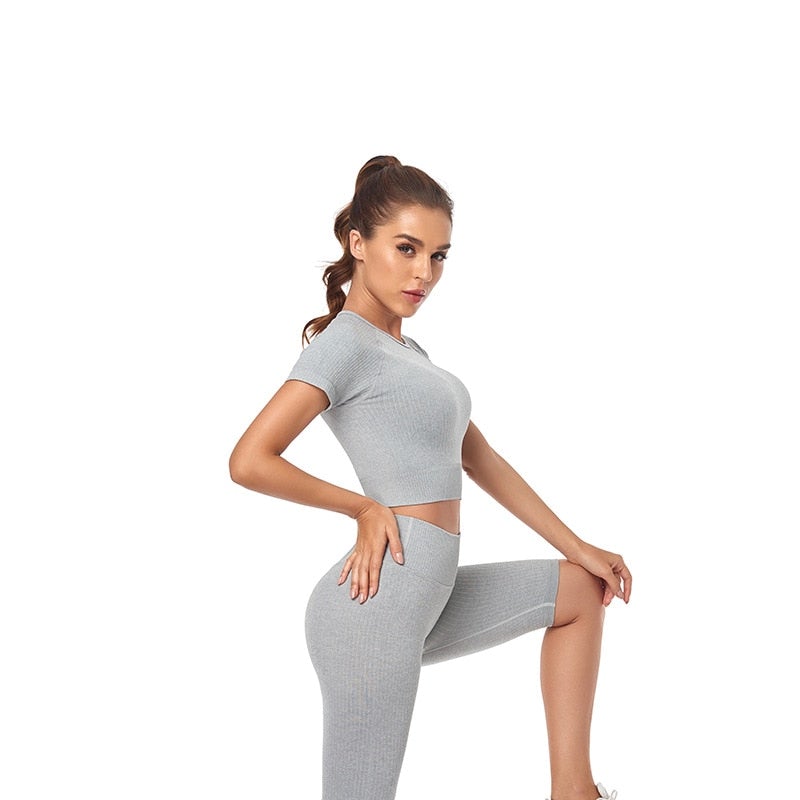 Women wearing a stylish short sleeve crop top yoga shirt in various colors, perfect for fitness and running.