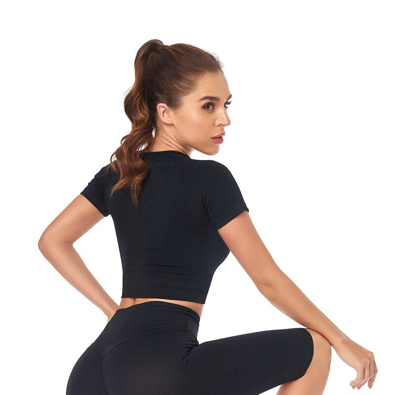 Women wearing a stylish short sleeve crop top yoga shirt in various colors, perfect for fitness and running.