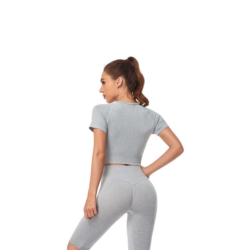 Women wearing a stylish short sleeve crop top yoga shirt in various colors, perfect for fitness and running.