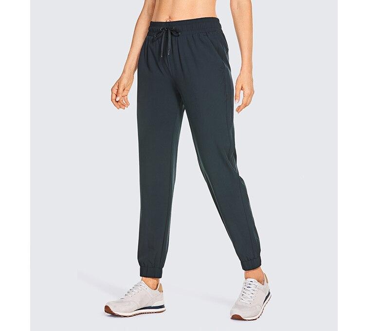 A pair of women's lightweight joggers pants in black with pockets and a drawstring elastic waist, perfect for athletic and casual wear.
