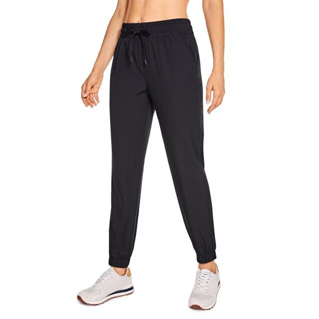 A pair of women's lightweight joggers pants in black with pockets and a drawstring elastic waist, perfect for athletic and casual wear.