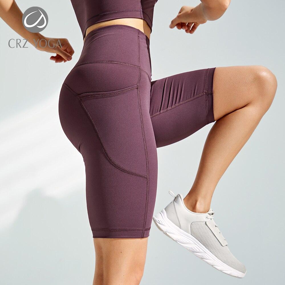 Women's Naked Feeling Workout Shorts in black, featuring a high waist and 10-inch inseam, designed for yoga and athletic activities with pockets.