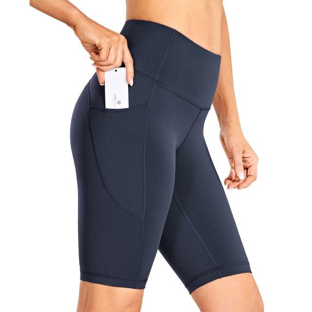 Women's Naked Feeling Workout Shorts in black, featuring a high waist and 10-inch inseam, designed for yoga and athletic activities with pockets.