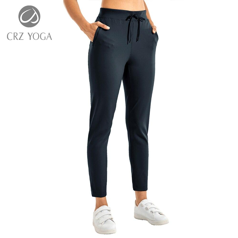 A pair of women's stretch casual jogger pants in black with a drawstring waist and zipper pockets, perfect for travel and lounging.