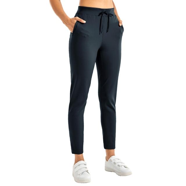 A pair of women's stretch casual jogger pants in black with a drawstring waist and zipper pockets, perfect for travel and lounging.
