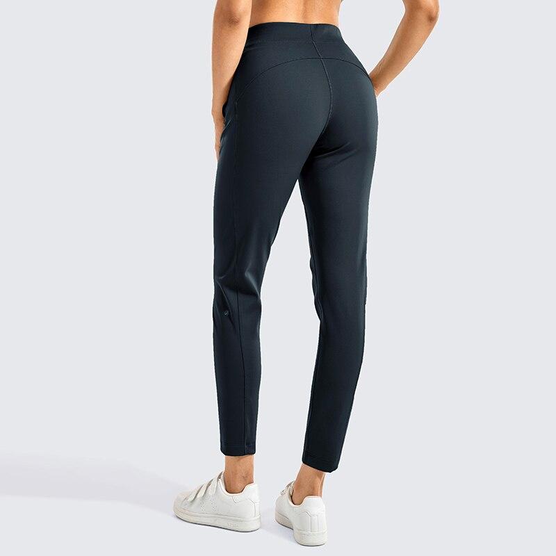A pair of women's stretch casual jogger pants in black with a drawstring waist and zipper pockets, perfect for travel and lounging.