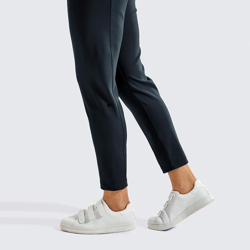A pair of women's stretch casual jogger pants in black with a drawstring waist and zipper pockets, perfect for travel and lounging.