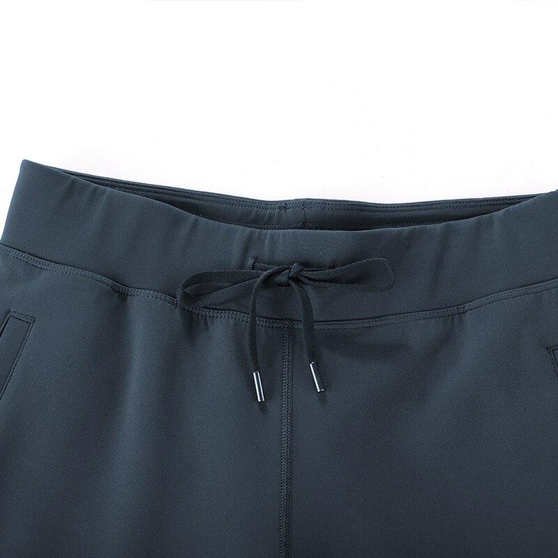 A pair of women's stretch casual jogger pants in black with a drawstring waist and zipper pockets, perfect for travel and lounging.