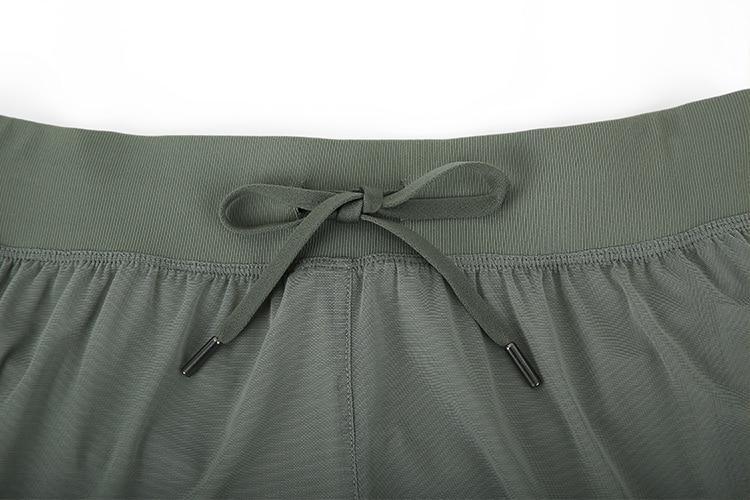 A pair of women's 2 in 1 workout running shorts featuring a quick-dry liner, elastic waistband, and a small pocket, designed for comfort and performance.