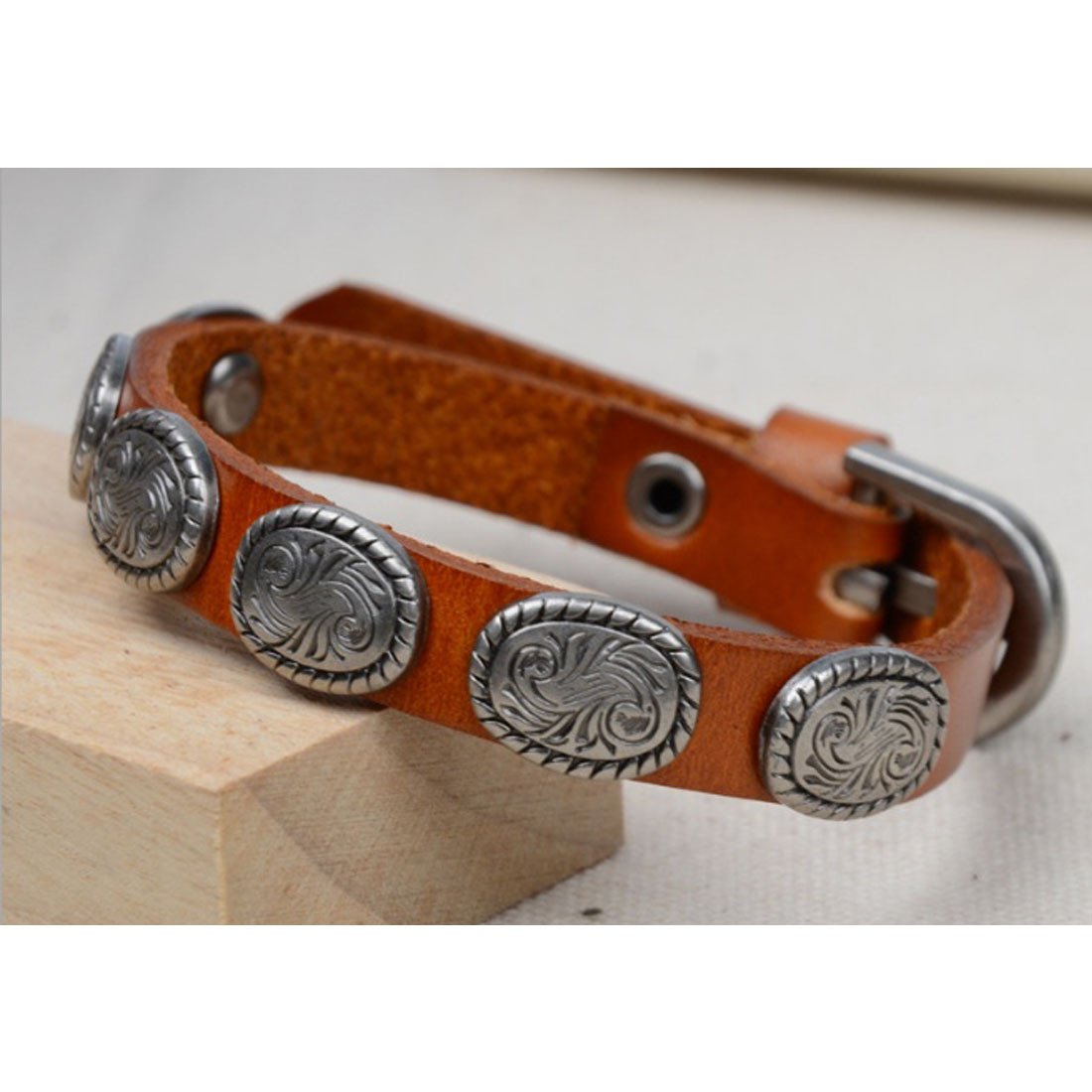 A stylish WRANGLER Vintage Look Genuine Leather Bracelet featuring antique silver medallions, showcasing its rugged design and adjustable buckle.