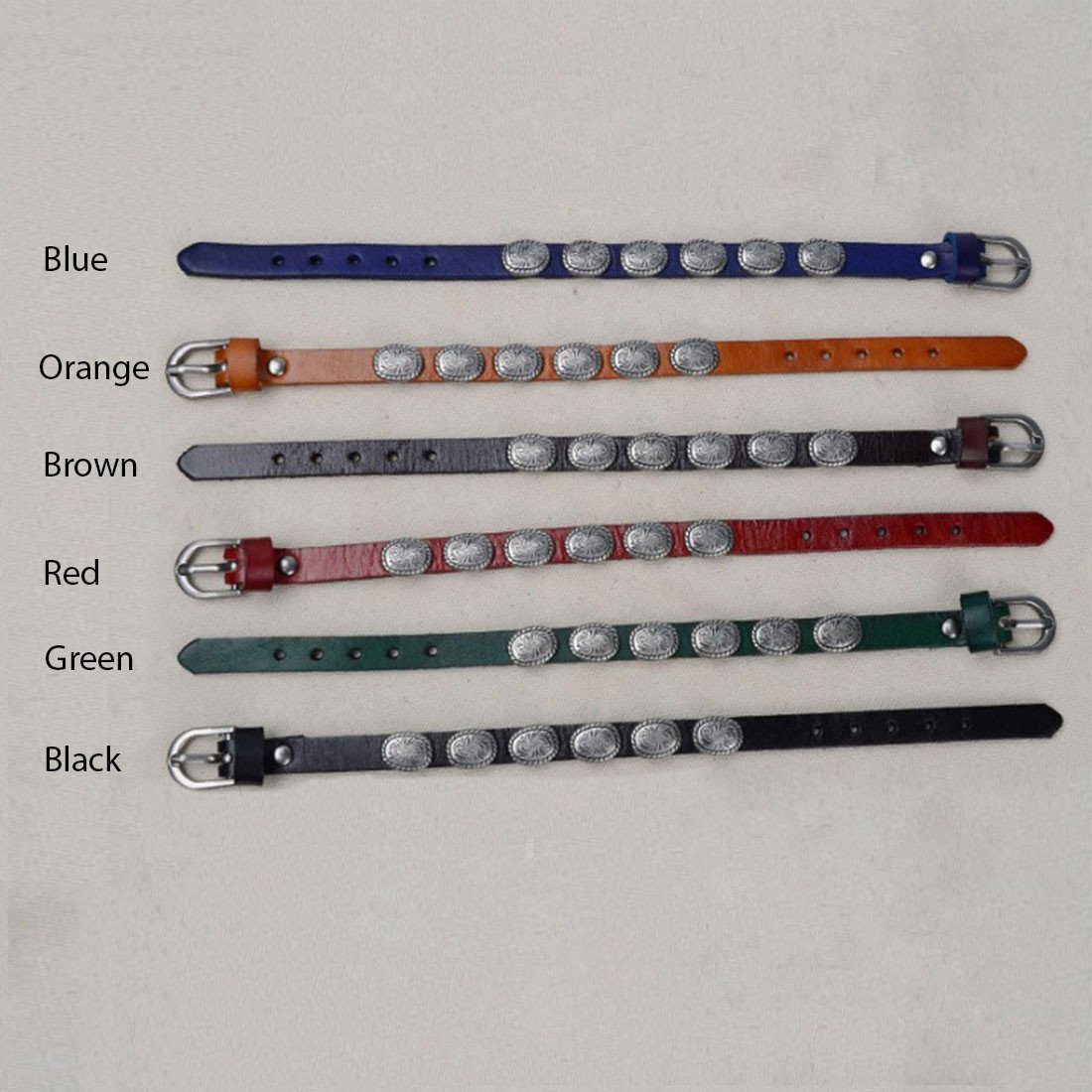 A stylish WRANGLER Vintage Look Genuine Leather Bracelet featuring antique silver medallions, showcasing its rugged design and adjustable buckle.