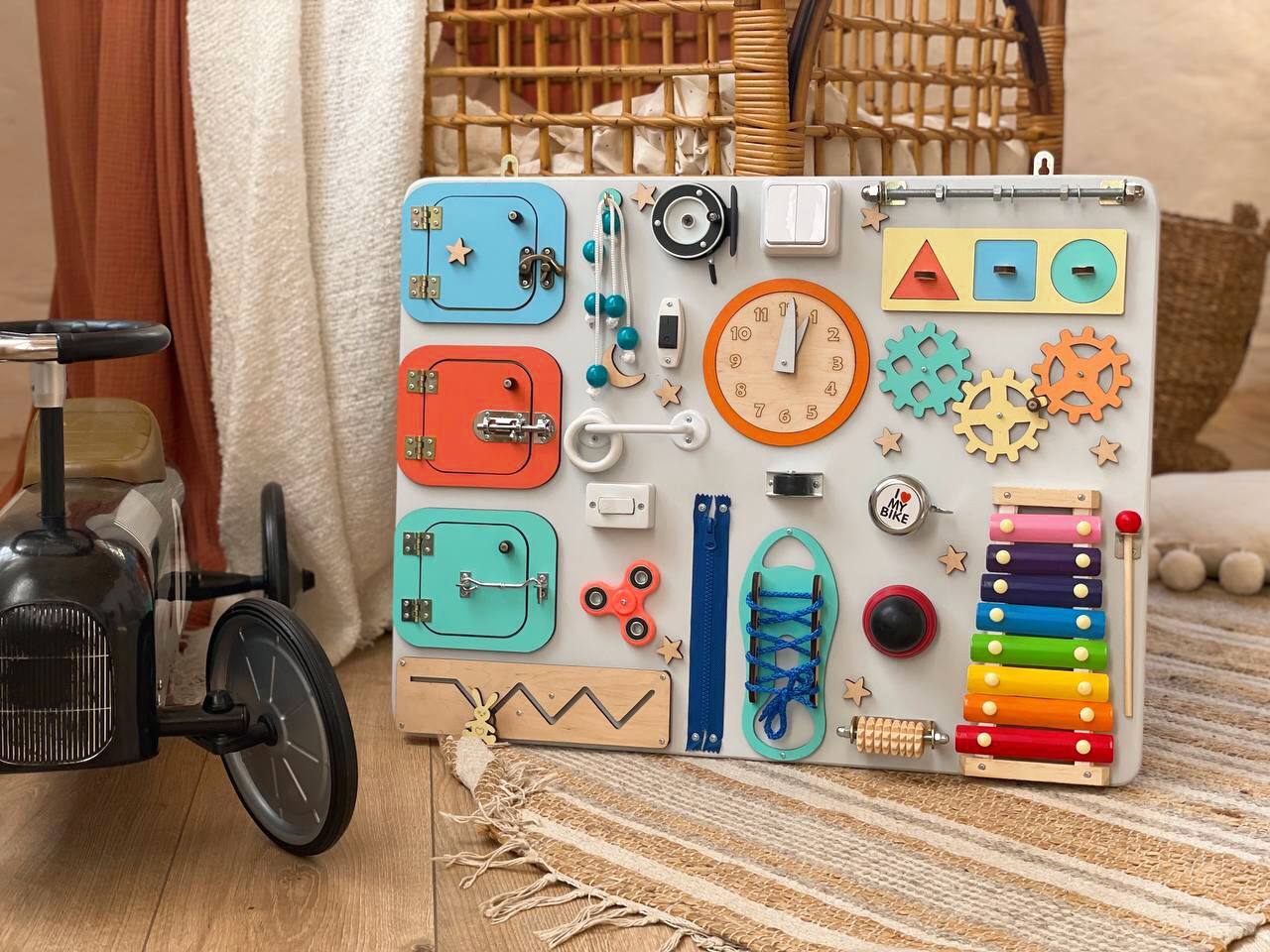 Multicolored Busy Board MAXI for toddlers featuring various engaging activities to enhance motor skills and creativity.