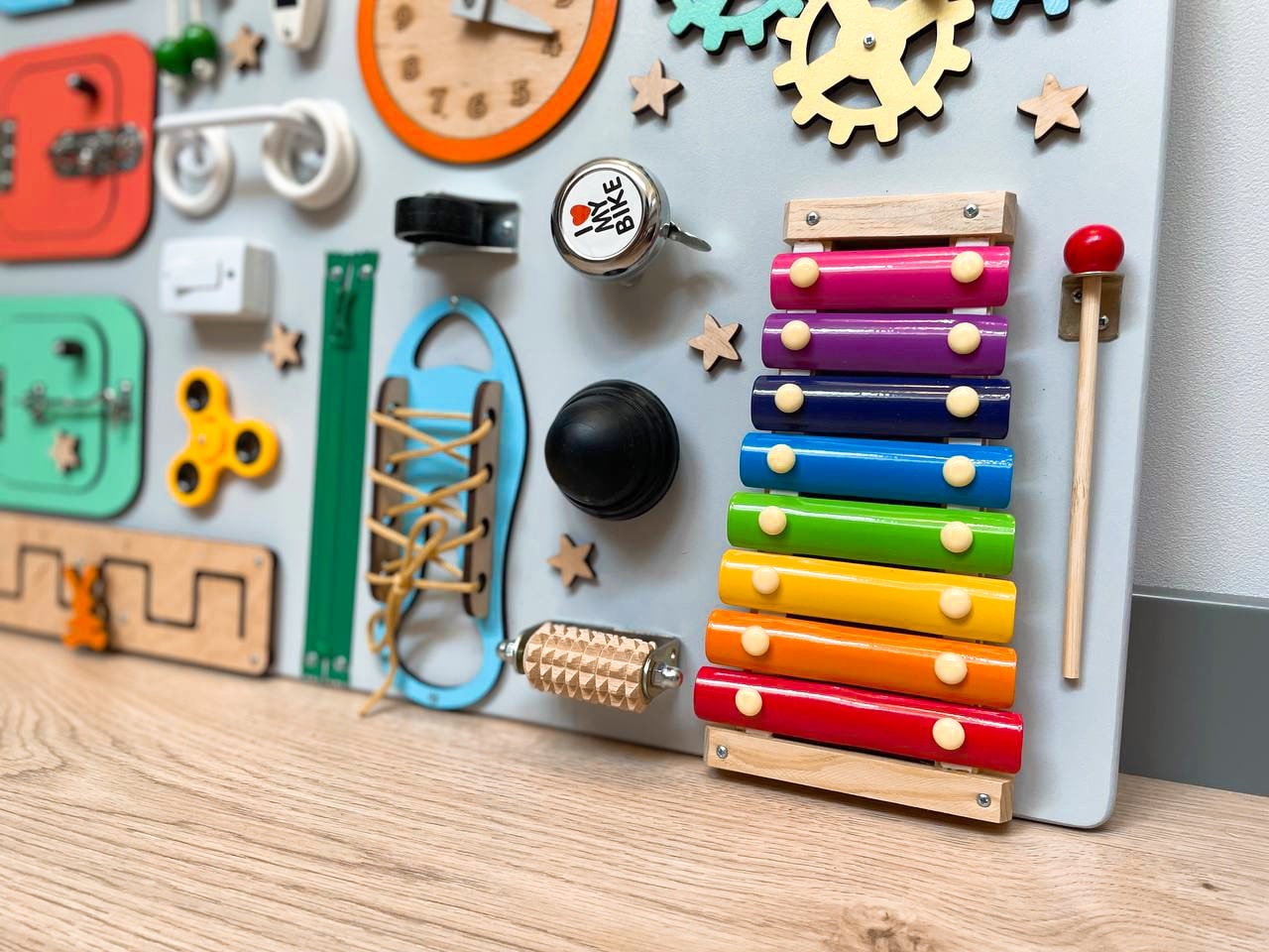 Multicolored Busy Board MAXI for toddlers featuring various engaging activities to enhance motor skills and creativity.