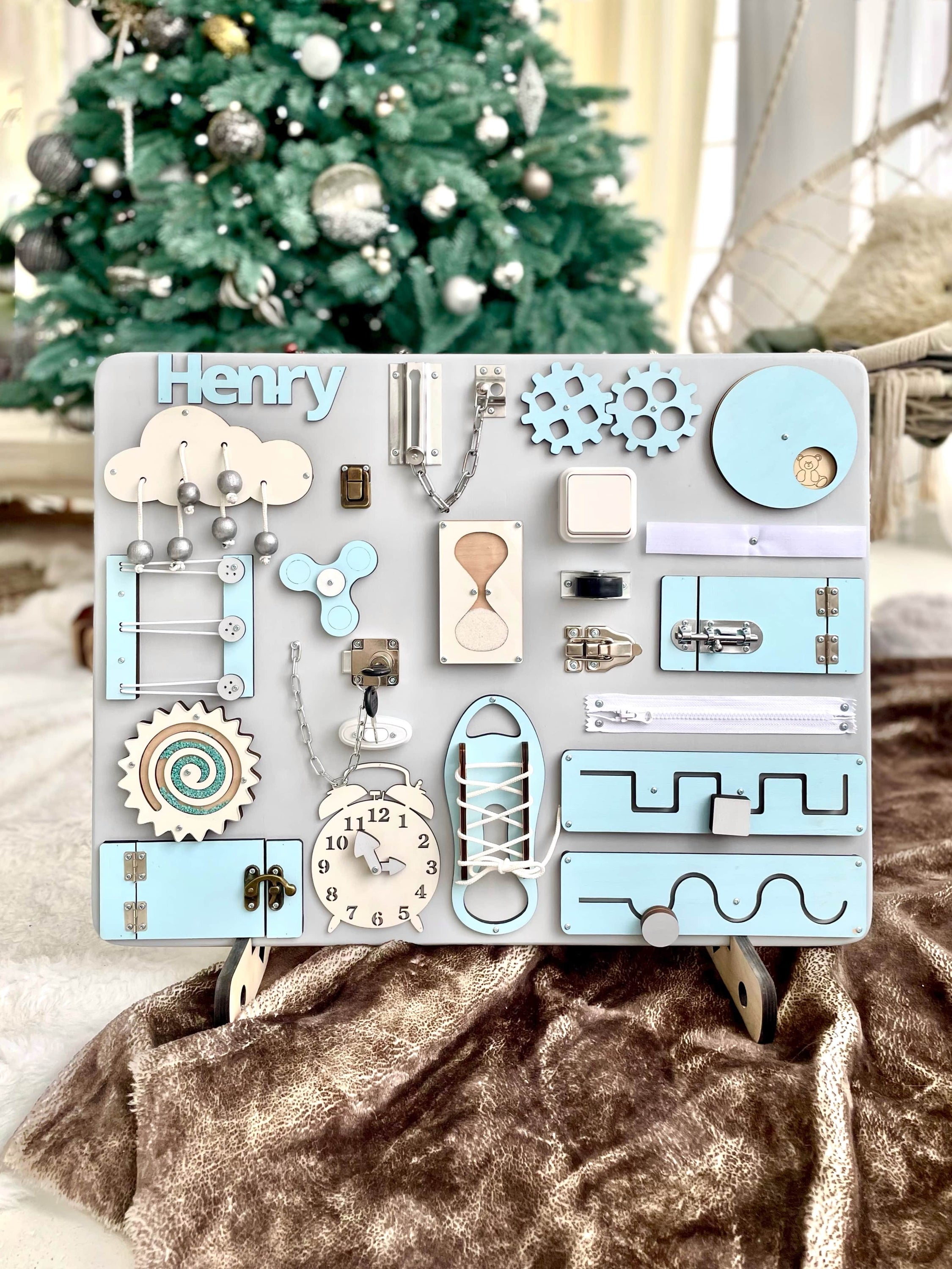 Busy Board MAXI in pastel blue, featuring various interactive elements for children's development.
