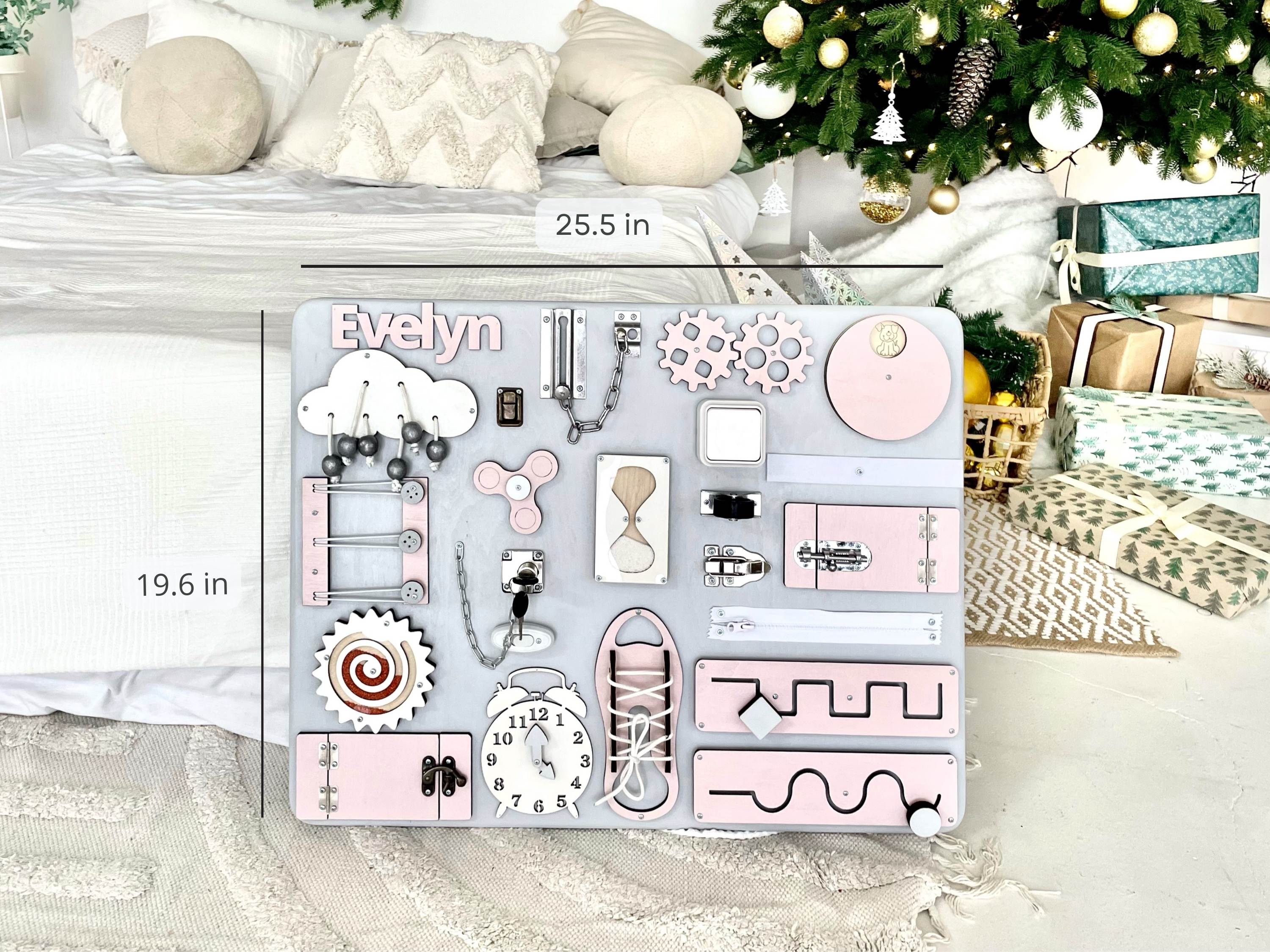 Pastel pink Busy Board MAXI featuring various interactive elements for children's development.