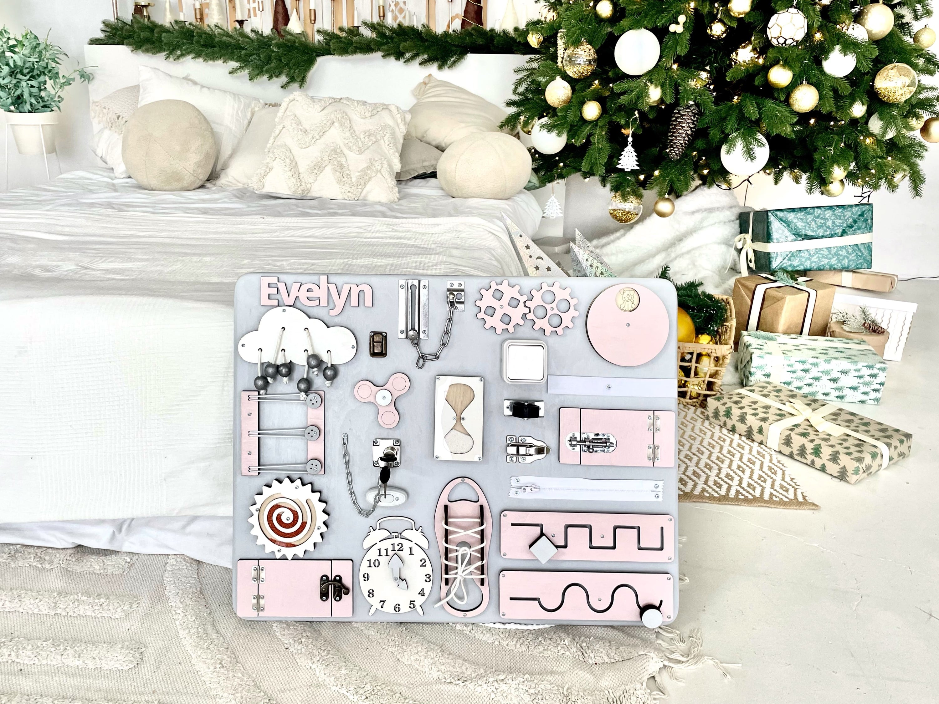Pastel pink Busy Board MAXI featuring various interactive elements for children's development.