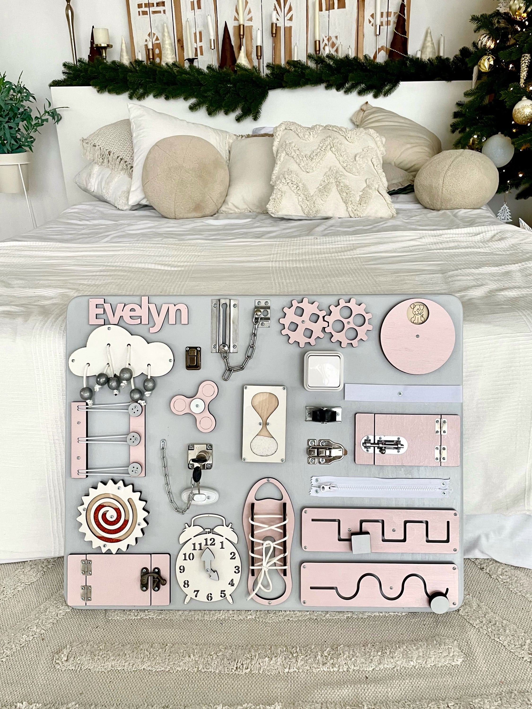 Pastel pink Busy Board MAXI featuring various interactive elements for children's development.