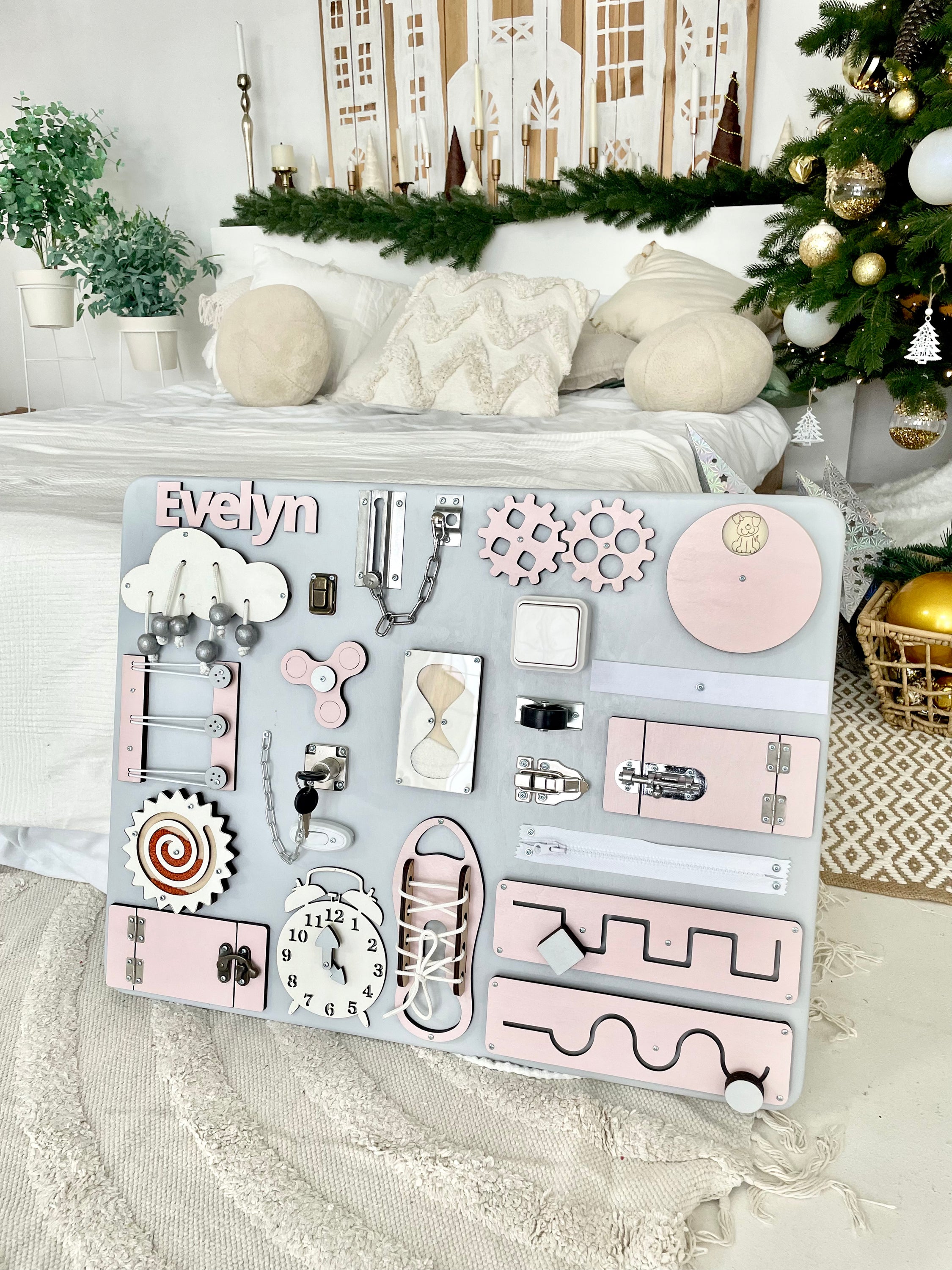 Pastel pink Busy Board MAXI featuring various interactive elements for children's development.