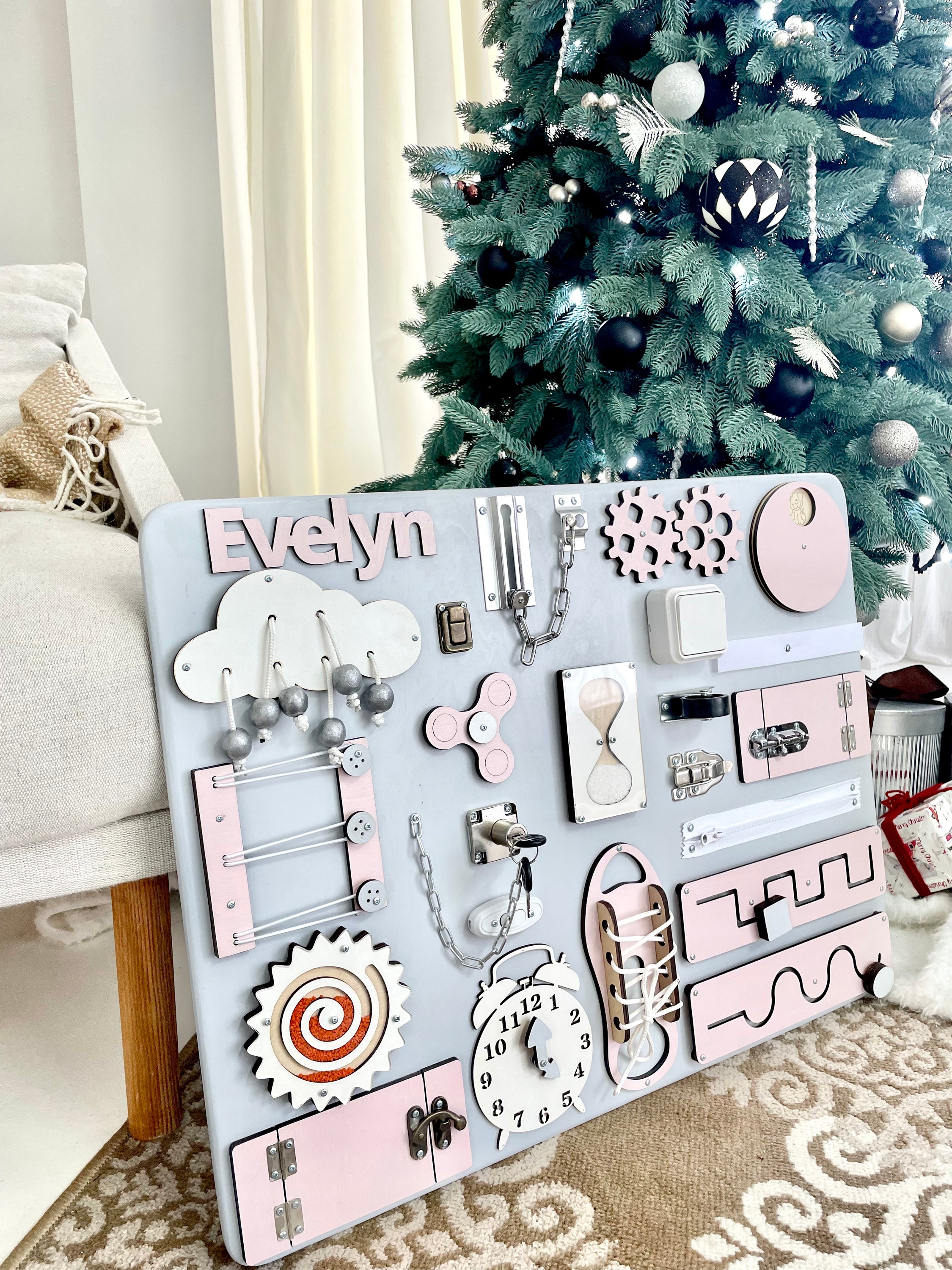 Pastel pink Busy Board MAXI featuring various interactive elements for children's development.