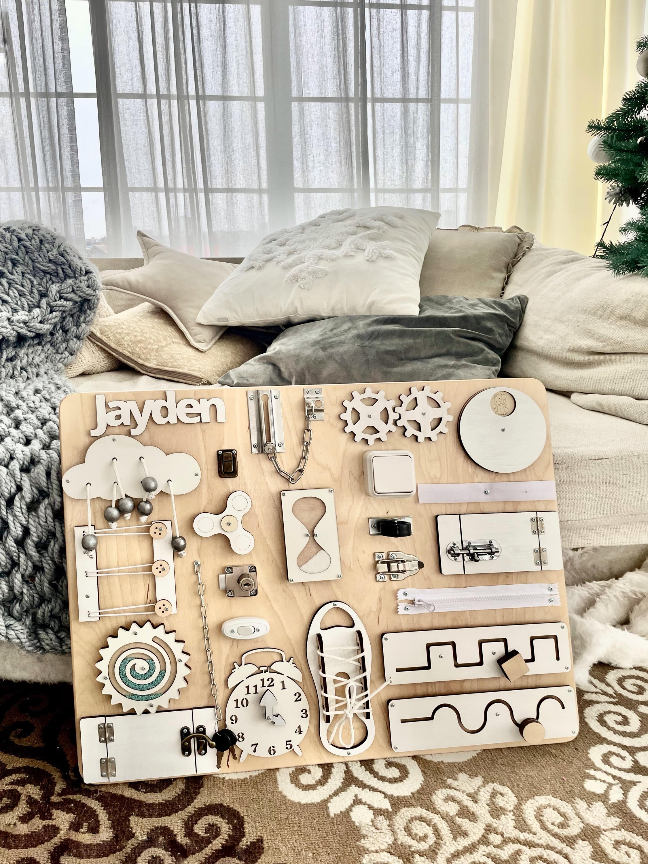 Busy Board MAXI in white wood, featuring various interactive elements for children's play and learning.