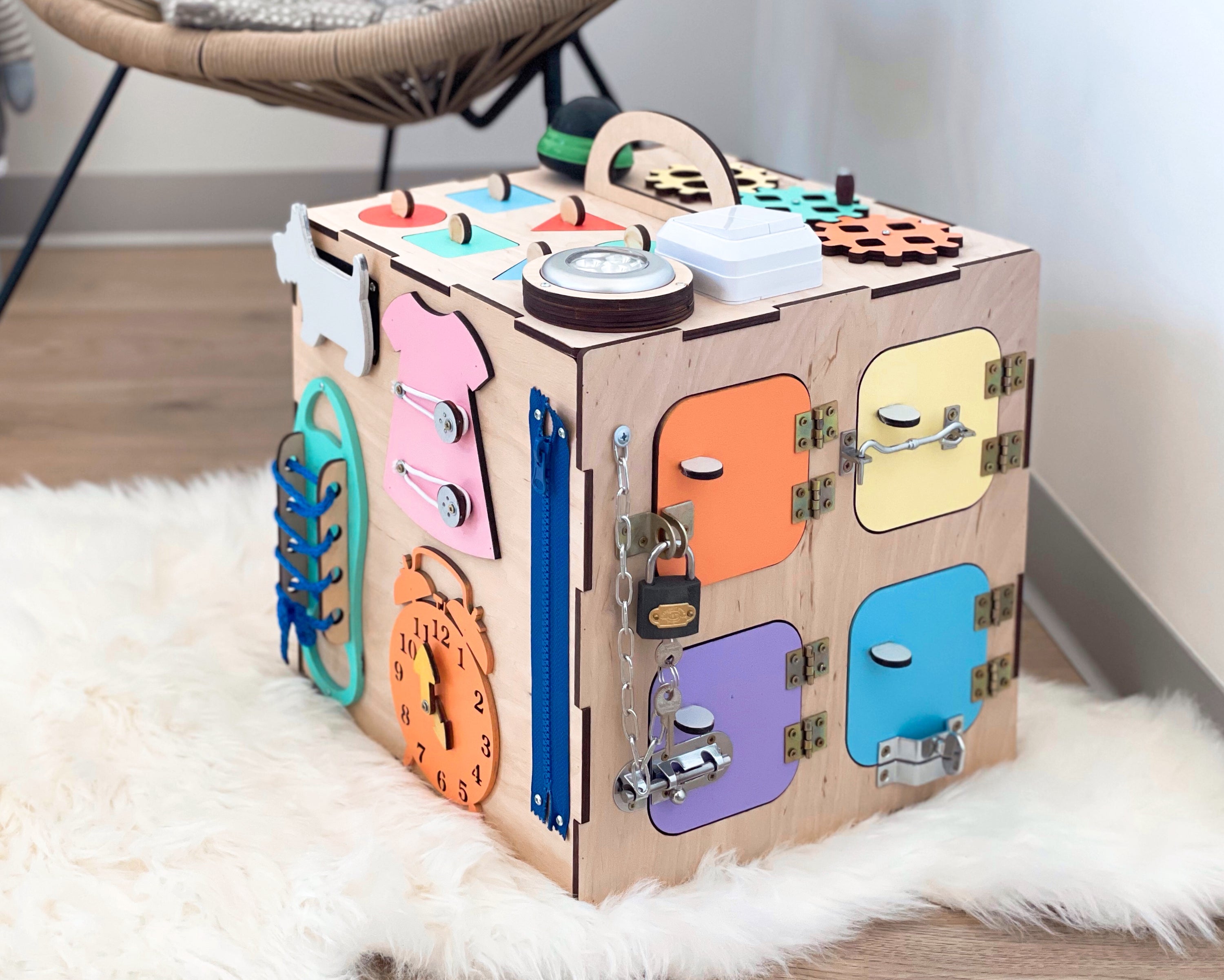 A colorful Busy Cube measuring 11 inches, featuring various engaging busy boards designed for children's skill development.