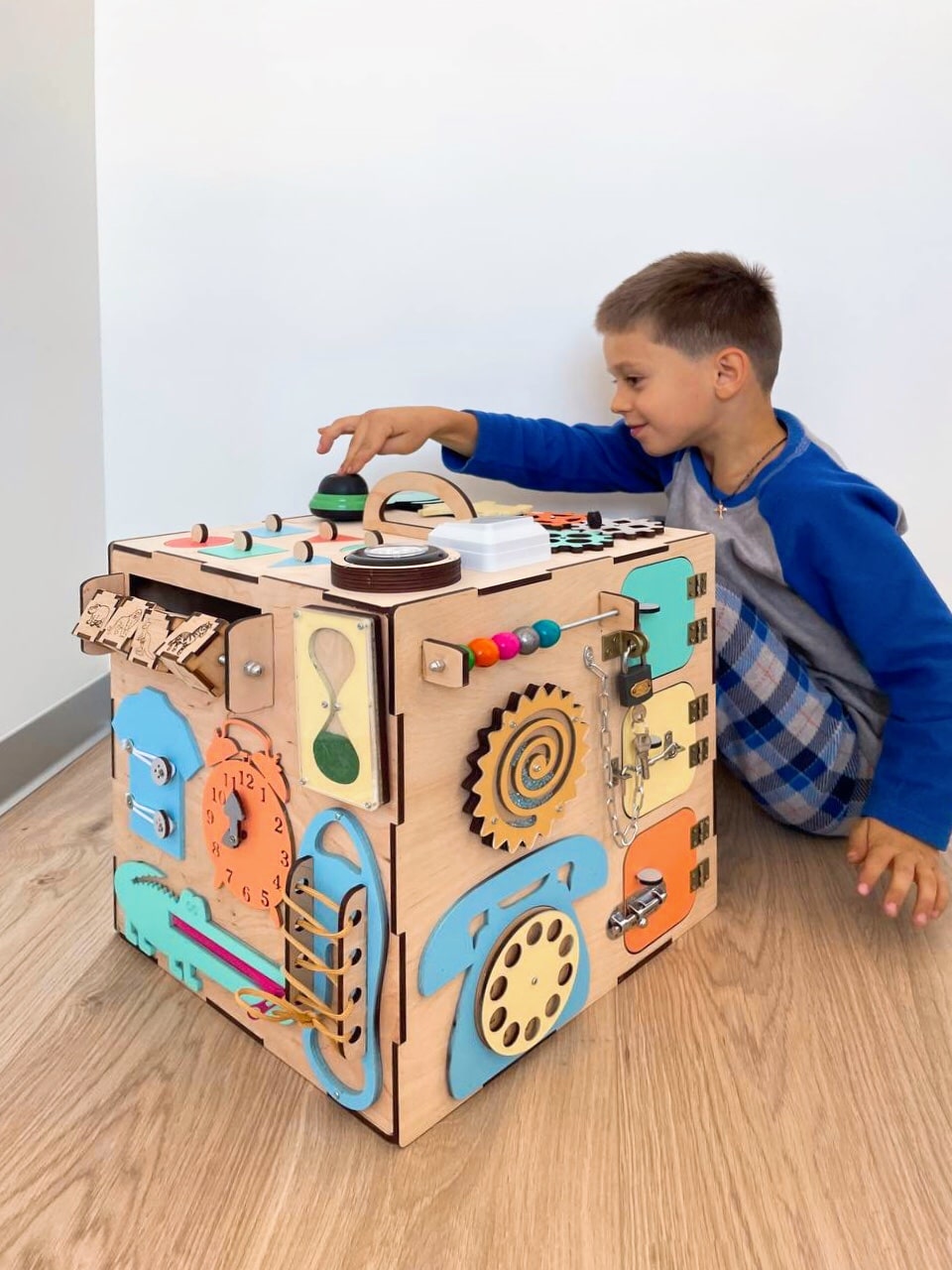 A colorful Busy Cube 13 inches featuring five busy boards with various engaging game elements for children's skill development.