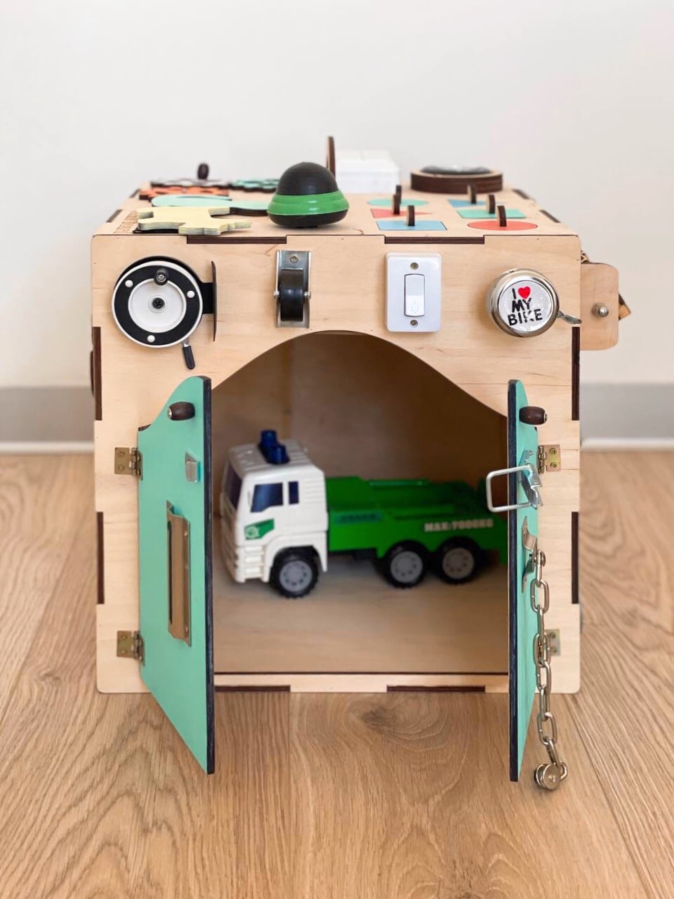 A colorful Busy Cube 13 inches featuring five busy boards with various engaging game elements for children's skill development.