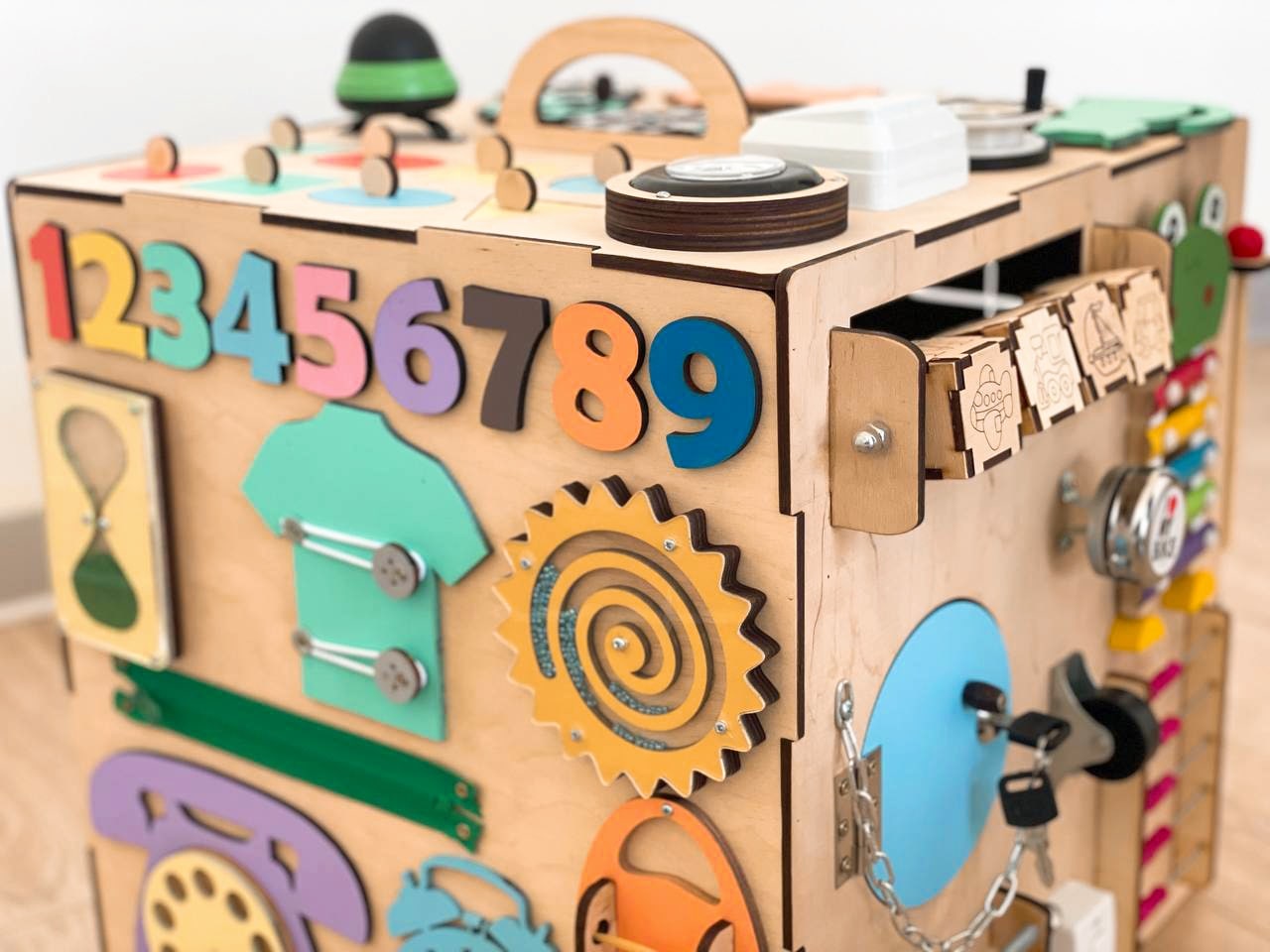 A colorful Busy Cube measuring 15 inches, featuring various engaging busy boards designed for children's skill development and creativity.