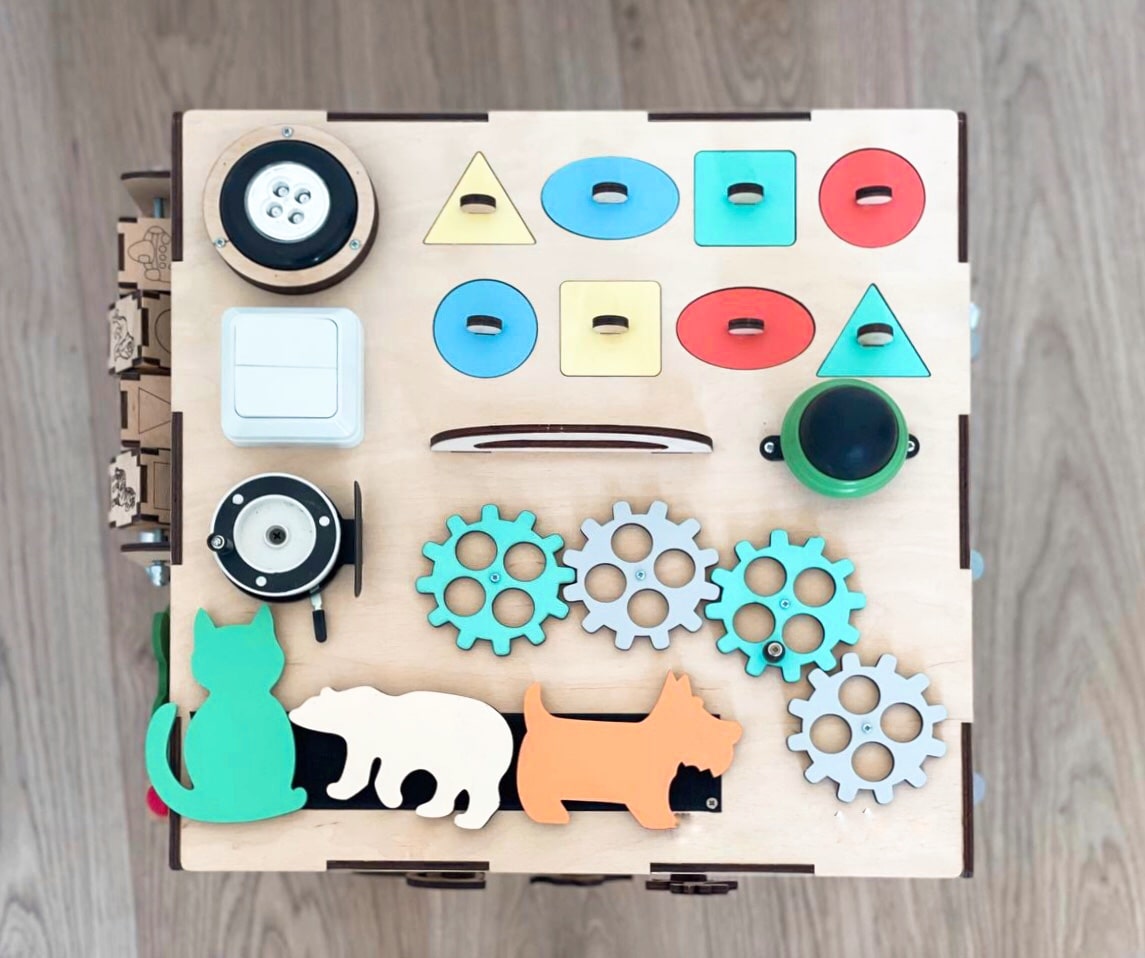 A colorful Busy Cube measuring 15 inches, featuring various engaging busy boards designed for children's skill development and creativity.